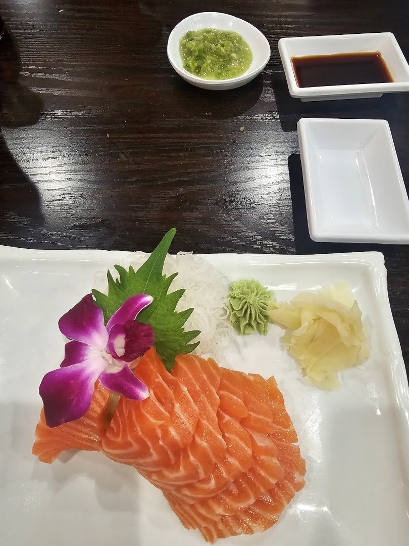 A sushi restaurant dining table with shared plates.